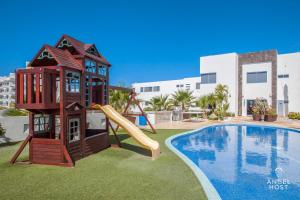 een speeltuin met een glijbaan naast een zwembad bij Stylish Condo with Pools Gym Sunset Bay Views in La Paz