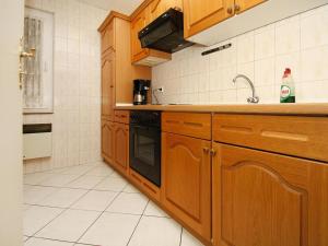 a kitchen with wooden cabinets and a sink at Feriensiedlung Am Grundlossee in Sewekow in Sewekow