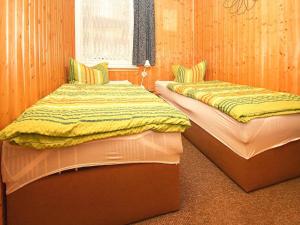 two beds sitting next to each other in a room at Feriensiedlung Am Grundlossee in Sewekow in Sewekow