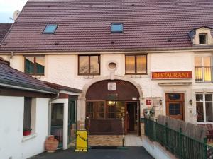 un edificio con tetto marrone e un ingresso di Hôtel Le Saint Martin a Bourg-Sainte-Marie