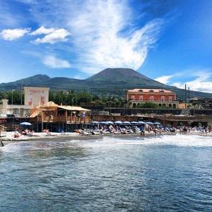 a group of people on a beach with a mountain in the background at Antica resina Appartamento Scavi in Ercolano +19 photos