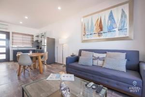 een woonkamer met een blauwe bank en een tafel bij Stylish Condo with Pools Gym Sunset Bay Views in La Paz