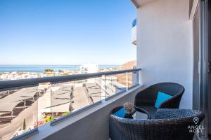 een balkon met een stoel en uitzicht op de oceaan bij Stylish Condo with Pools Gym Sunset Bay Views in La Paz +128 foto's