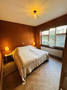 a bedroom with a large bed and a window at Two bedroom apartment 150m from the beach in De Haan +9 photos