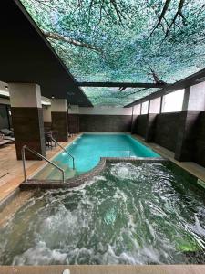 兹拉蒂博尔Ilic Prestige wellness & spa Zlatibor的一个天花板很高的大型游泳池