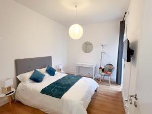 a bedroom with a bed with blue pillows and a desk at Martins' Happy Home in Coimbra