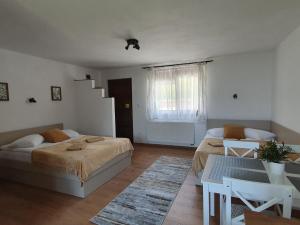 a bedroom with two beds and a table and a staircase at Pensiunea Bogada in Praid