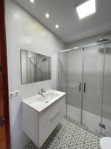 a white bathroom with a sink and a shower at Lourdes House Beach in Caleta De Velez