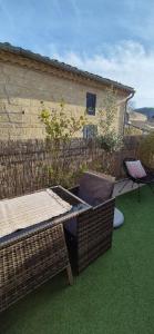 a patio with a table and chairs on the grass at Proche d'Uzès la Terrasse du soleil levant in Collias +23 photos