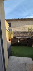 a backyard with chairs and a fence and grass at Proche d'Uzès la Terrasse du soleil levant in Collias