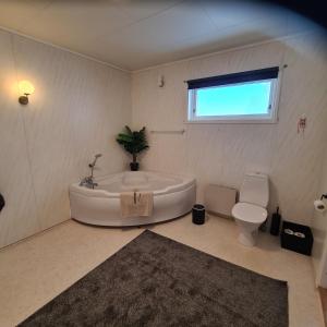 a white bathroom with a tub and a toilet at Skipperhuset in Sund +22 photos