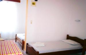 a room with two twin beds in a room at Vaso Rooms in Livadakia
