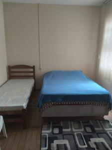a bedroom with two beds and a table and a rug at Hostel Baladi in Socorro