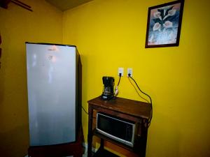 a yellow room with a refrigerator and a microwave at Cabaña Blue con free E con WIFI in San Cristóbal de Las Casas