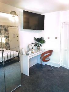 a room with a desk and a chair and a bed at Bay Lodge in Penzance