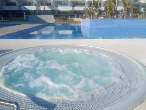 a bath tub filled with water next to a swimming pool at ELIO Terrazas de Campoamor in Orihuela Costa
