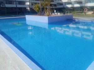 a swimming pool with blue water in a building at ELIO Terrazas de Campoamor in Orihuela Costa