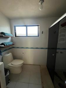 a bathroom with a toilet and a window at Turtle Beach Villas in Zihuatanejo +60 photos