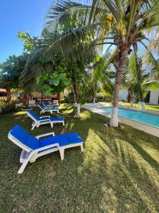 a group of lounge chairs sitting next to a swimming pool at Turtle Beach Villas in Zihuatanejo