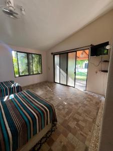 a bedroom with a bed and a large window at Turtle Beach Villas in Zihuatanejo