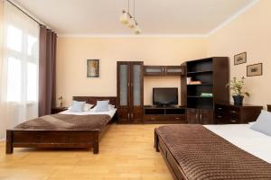 a bedroom with two beds and a television at Caffe latte apartment in Kraków