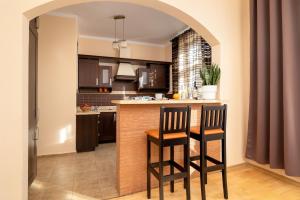 a kitchen with two chairs and a bar in a room at Caffe latte apartment in Kraków +25 photos