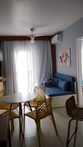 a living room with a couch and a table and chairs at Boulevard Riviera Flat - VISTA MAR E CLUBE in Riviera de São Lourenço