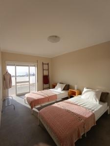 two beds in a room with a window at Belavista 3 in Vila Praia de Âncora