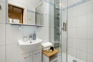 a bathroom with a sink and a shower at Caffe latte apartment in Kraków