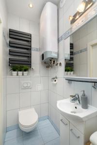 a white bathroom with a toilet and a sink at Caffe latte apartment in Kraków