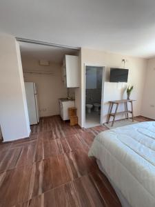 ein Schlafzimmer mit Bett und eine Küche mit Tisch in der Unterkunft Africa Suites in Cordoba