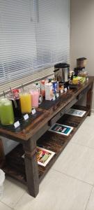 una larga mesa de madera con algunas bebidas. en Hotel LF by Feliciano Joaçaba, en Joaçaba 17 fotos más