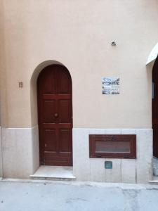un edificio con porta in legno e ingresso di Grecale Apartment a Trapani Altre 5 foto
