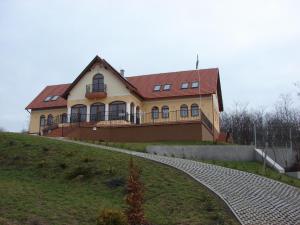 una casa en la cima de una colina con una pasarela en Berezdtető Vendégház, en Cserépfalu