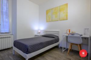 a bedroom with a bed and a desk and a chair at Affittacamere Il Viaggiatore in La Spezia +11 photos