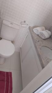 a white bathroom with a toilet and a sink at Apt lindo e novo vista mar com garagem orla de Pituba in Salvador +24 photos