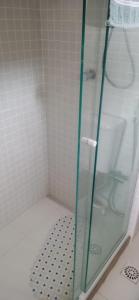 a shower with a glass door in a bathroom at Apt lindo e novo vista mar com garagem orla de Pituba in Salvador