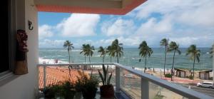a balcony with a view of the beach and the ocean at Apt lindo e novo vista mar com garagem orla de Pituba in Salvador