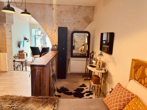 a living room with a table and a mirror at La Tannerie, centre historique, fibre, ESS, rez-de-chaussée, BedinShop in Romans-sur-Isère