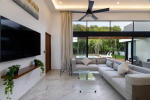 a living room with a couch and a flat screen tv at ¡Increible! Villa Luz de Luna in Akumal