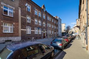 a row of cars parked on a city street at Caffe latte apartment in Kraków