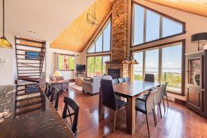 a dining room with a table and chairs and a fireplace at La Grande Ourse de Charlevoix in Petite-Rivière-Saint-François