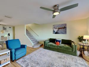 Una sala de estar con un sofá verde y una silla azul. en Sandcastle Townhomes #24, en Navarre