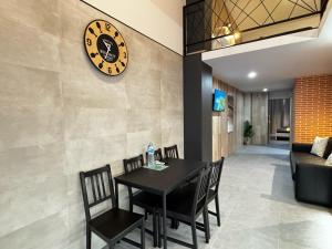 ein Esszimmer mit einem Tisch und einer Uhr an der Wand in der Unterkunft Cruilles 13 in Valencia