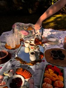 a table with food and a person reaching for a tea pot at La Maison d' Ivonne in Antón +63 photos