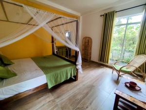 a bedroom with a bed with a canopy at Green Eyes Villa in Habaraduwa