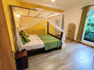 a bedroom with a canopy bed and a wooden floor at Green Eyes Villa in Habaraduwa +13 photos