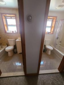 a bathroom with two toilets and a sink and a tub at Nice rooms Woodside in Queens +36 photos