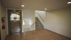 a hallway with stairs and a door in a building at Hotel Virginia in Linhares
