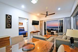een woonkamer met een bank en een tafel bij Stylish Condo with Pools Gym Sunset Bay Views in La Paz